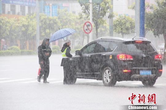 钦州市遭特大暴雨袭击，交警雨中指挥交通。陆祖江摄