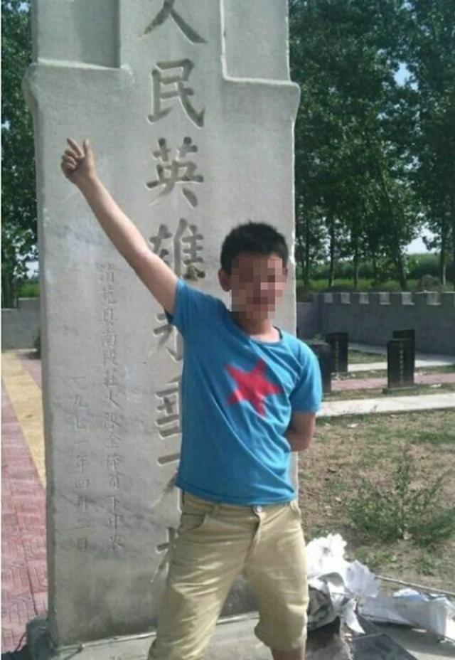 少年手指纪念碑拍照。