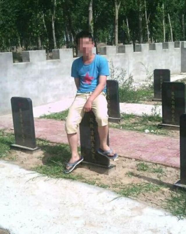 少年坐在烈士墓碑上。