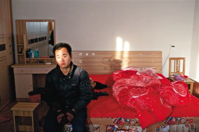 12月11日，曲周县安寨镇西马连固村，来自越南的妻子出走后，袁迎宾坐在婚床前发呆。